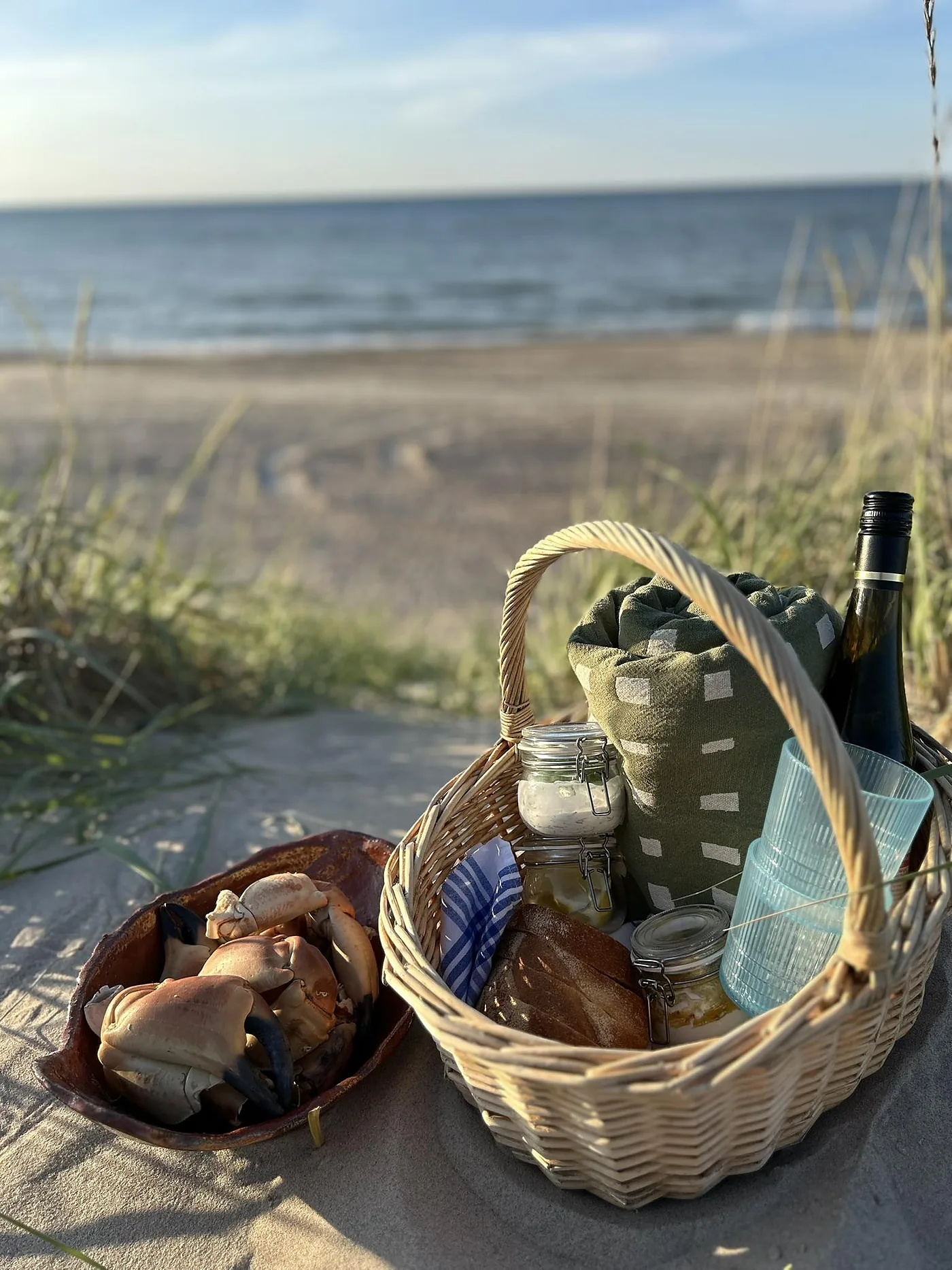 Krabbekløer, vin og glas stillet frem i klitten ved Thorupstrand.